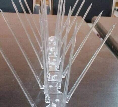 Clear bird spikes installed on a balcony ledge